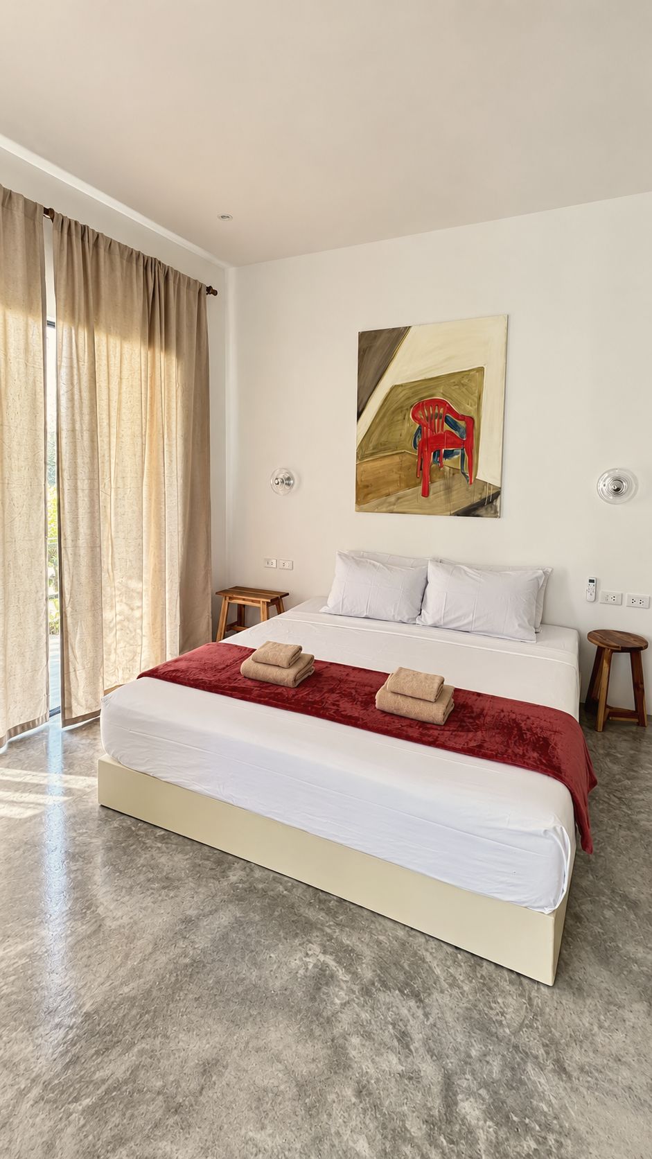 Bedroom with sheer curtains and red throw