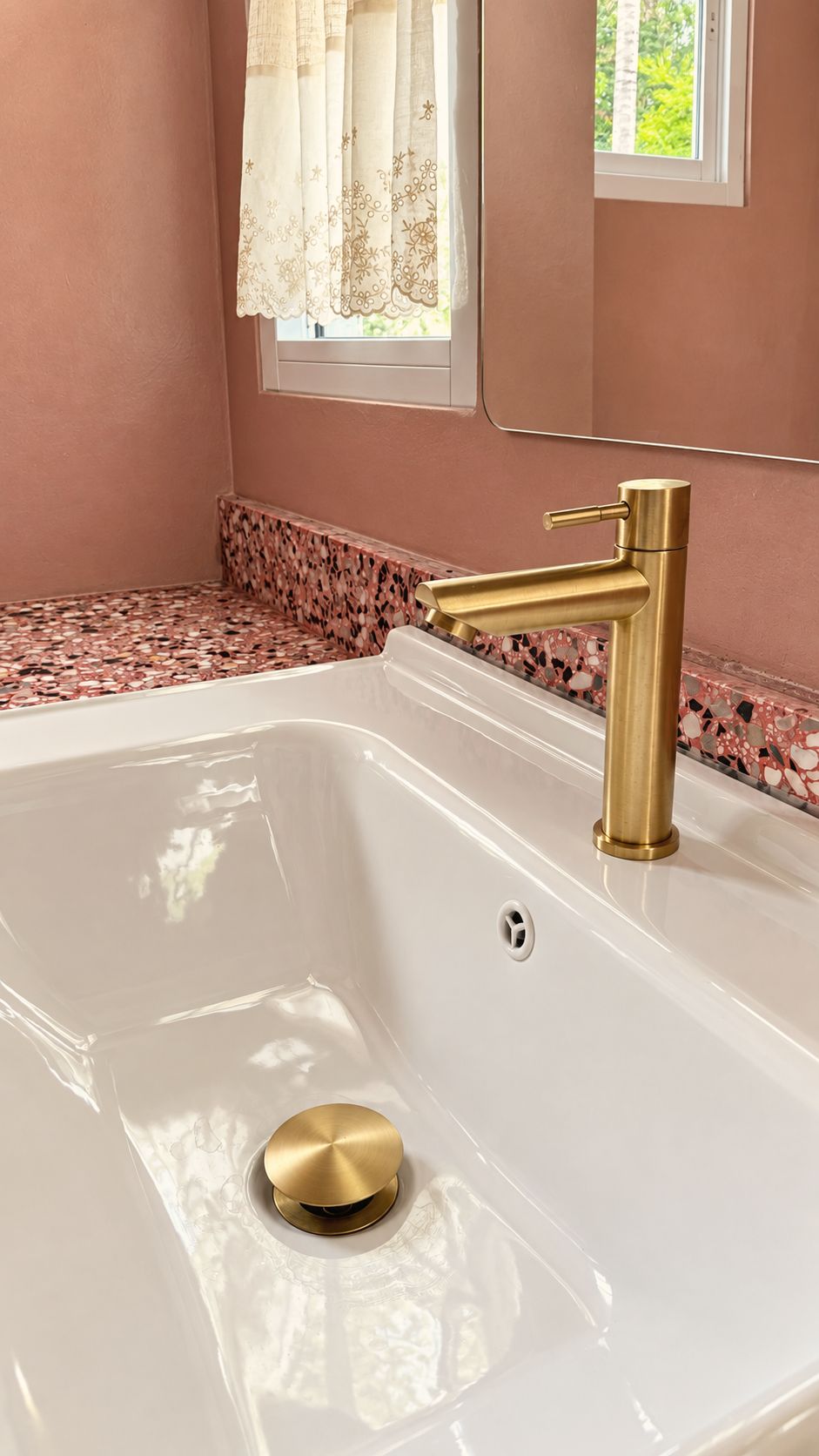 Soaking tub in a pink terrazzo bathroom