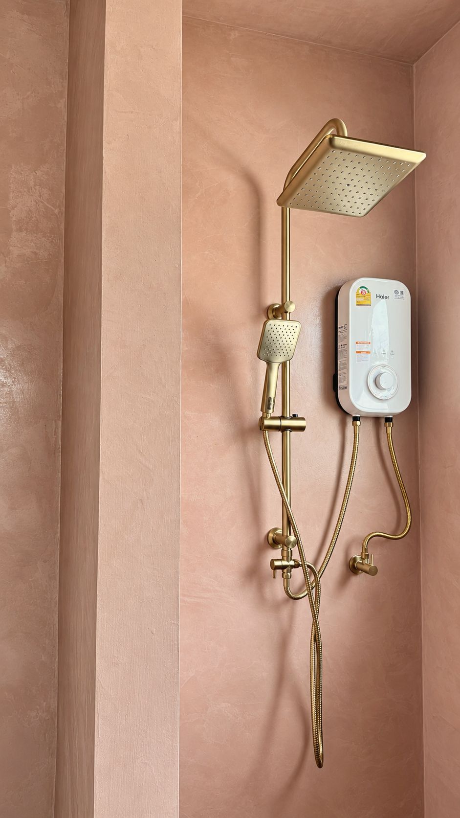 Brass rain shower in the pink bathroom